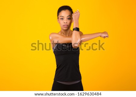Fitness And Workout. Afro Woman Exercising Stretching Deltoid Arm Muscle Posing Over Yellow Studio Background