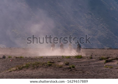 Horse riding at the National Park of Bromo Tengger Semeru, East Java, Indonesia, a little bit covered with dust from the desert
