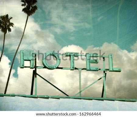  aged and worn vintage photo of hotel sign and palm trees                              