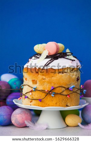 Easter cake on cake stand with painted eggs near
