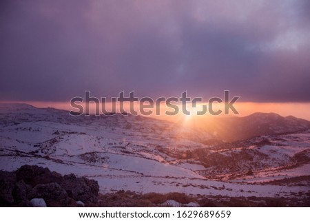 sunset over mountains covered with snow