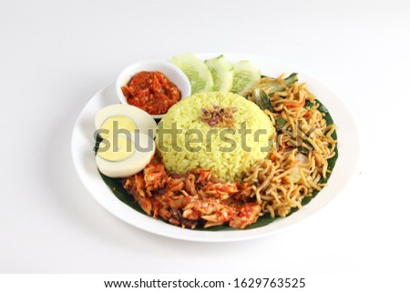Nasi Kuning, Manadonese turmeric rice with assorted side dishes such as shredded cob, fried noodle, boiled egg, chili paste and fresh vegetables served with banana leaf on plate, white isolated. Royalty-Free Stock Photo #1629763525