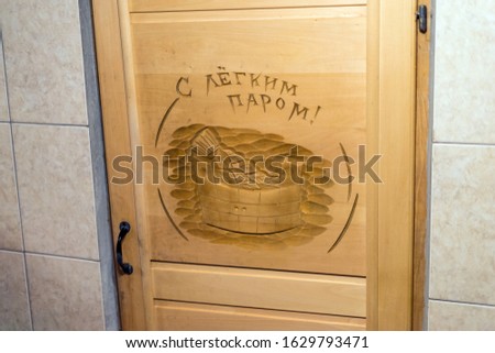 Wooden door to the sauna with a picture.