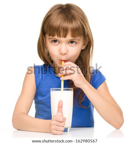 Cute little girl drinks milk using a drinking straw, isolated over white