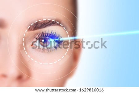 Beautiful female eye with blue laser ray. Vision correction surgery on female eye. Royalty-Free Stock Photo #1629816016