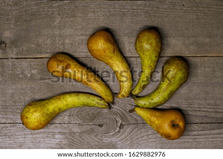 Composition of several ugly pears on an old wooden background.