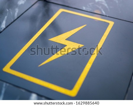 Wireless built-in charging station for smartphone and tablet. The charge sign is shown on a black table in a cafe, close-up. Free charging station for electronic devices in a public place.