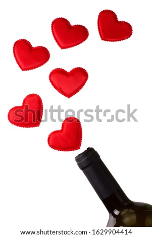 Bottle of wine with hearts on red background. Levitation. Top view. Copy space. 