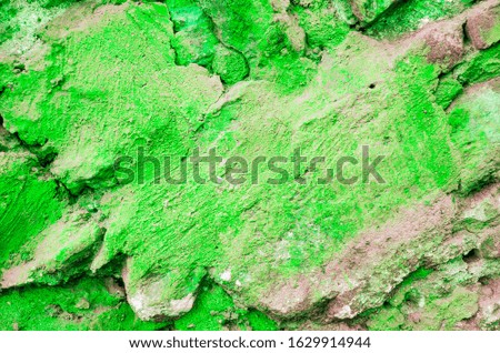 Wall covered with old cracked stucco, tinted green. Bright neon backdrop. Modern urban industrial concept. Copy space. Selective focus image.