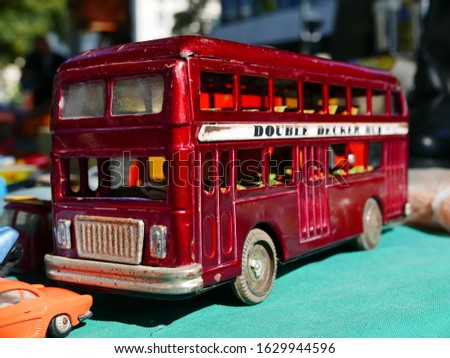 A selective focus shot of a cute red bus figurine on a blue surface