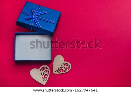 Open blue box on a red background with an empty place for a gift with hearts with copy space. Gifts for men for the holidays. Valentine's Day, Father's Day, February 23
