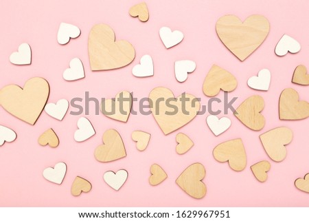 Wooden white and brown hearts on pink background