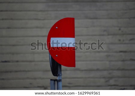white brick curved sign on a red background on a pillar