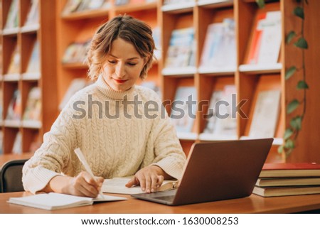 Young woman working on laptop in a library