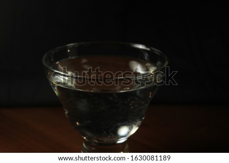 a glass of water on black background