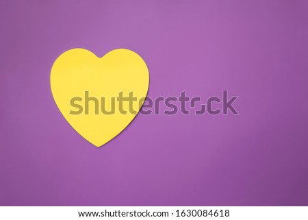 Composition with yellow heart on a purple background with place for text