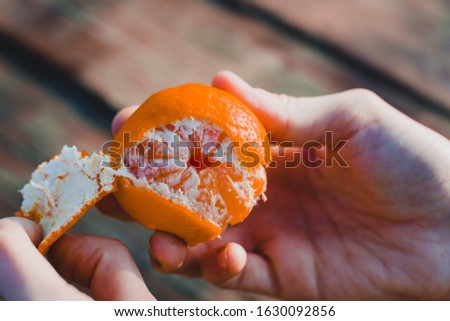 orange in hand on wooden background