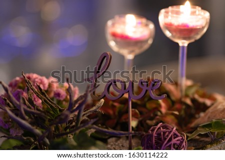 composition of dried flowers, flower arrangements, glass candle holders and a purple lettering Love. wonderful bokeh, useful photo for design, postcards or valentine's Day