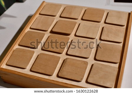 Wooden box with compartments to hold objects. It has multiple lids on it.