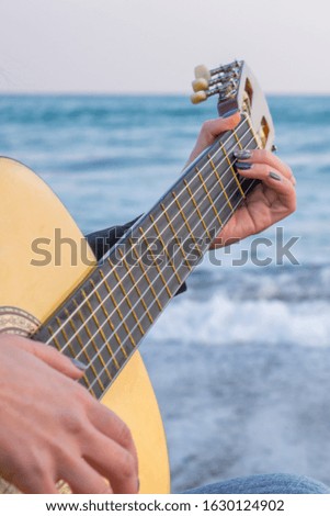 Girl with a guitar by the sea