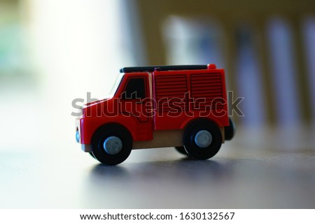 A closeup shot of a red toy truck with a blurred background