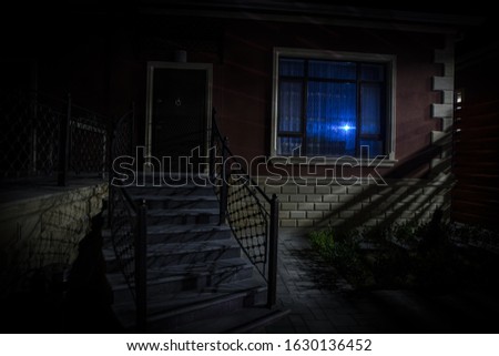 Old house with a Ghost in the at night. Horror silhouette at the window. Surreal lights. Horror Halloween concept