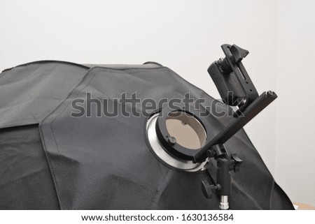 Photographic flash with softbox. The concept of taking photos with additional lighting. Flashlight on a tripod with a softbox.