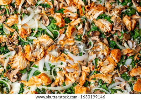 A top down background of pizza toppings featuring chicken, onion, mushrooms, and spinach.