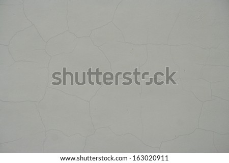 grey plastered wall with cracks 