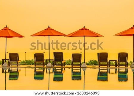 Beautiful sunrise around with umbrella and chair outdoor swimming pool for travel vacation