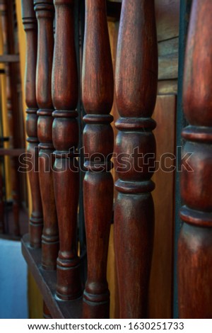 six vertical and textured hand-carved wooden bars in a light yellow and blue window
