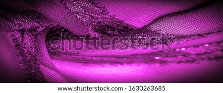 the ornament of the decor, the transparent fabric is purple-red with brightly innate stripes, the material allowing the light to pass through it so that the objects behind are clearly visible.