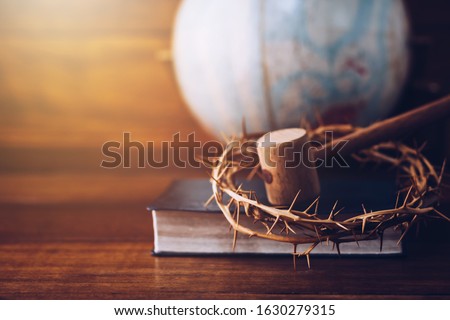Close up of crown of thorns of Jesus and wooden hammer look like Judge gavel on  bible over Blurred world globe  on wooden table. Christian background show God justice and Christ's redemption  concept