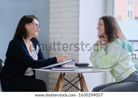 Woman social worker talking to teenage girl. Psychological assistance in adolescence. Mental health of adolescent children Royalty-Free Stock Photo #1630294057