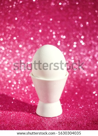 Easter background with fresh white egg over pink bokeh background