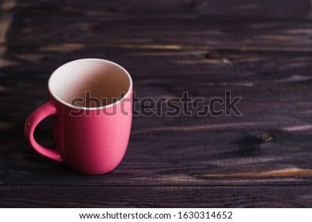 empty red mug on a dark wooden table