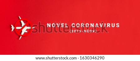 White airplane model toy on a red background. Prohibition sign. Ban on flights from China. Precautions and other details. Coronavirus Infection Royalty-Free Stock Photo #1630346290