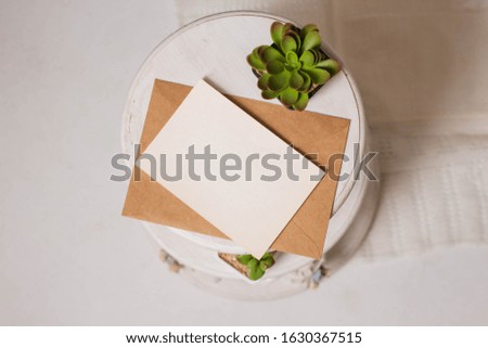 card mockup with plant in the pot in wooden round table. minimal invitation