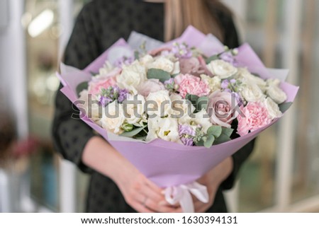 Beautiful bouquet in womans hands. the work of the florist at a flower shop. Delivery fresh cut flower. European floral shop.
