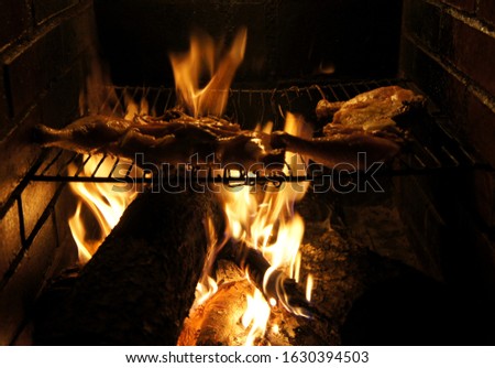 Chicken grilled using wood-fire as a cooking medium during a barbecue night time event