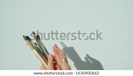 Paint brushes in the hand of painter.
