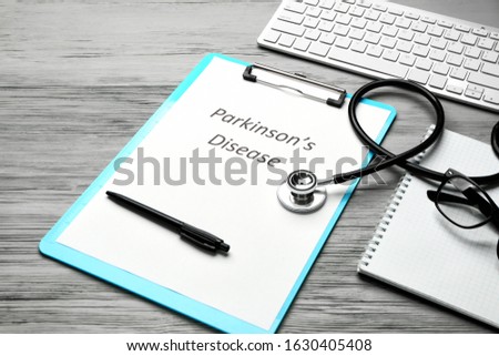 Clipboard with text PARKINSON'S DISEASE, stethoscope and computer keyboard on wooden background Royalty-Free Stock Photo #1630405408