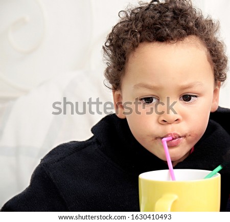 boy drinking with straw from  a cup with white background stock photo