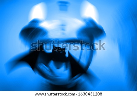 Silhouette of a mystical bat on a twilight blue background with a radial blur. Close up