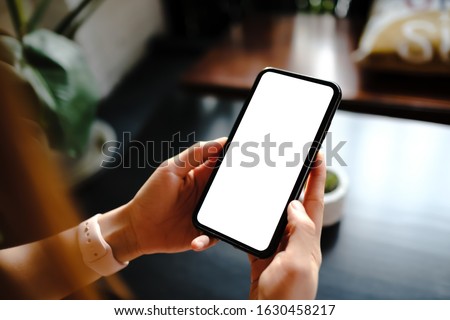 Close up of woman using cell phone,sending massages on the coffee shop.having sunbath.Phone with black screen,texting,video calls, Royalty-Free Stock Photo #1630458217