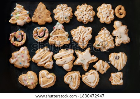 Christmas or New Year cookies on a dark background. in the form of a Christmas tree, New Year's star, New Year's hear, New Year's pretzel. Homemade baking.