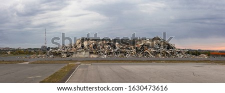 Crumbled concrete building with piles of debris. panoramic photo shot Royalty-Free Stock Photo #1630473616