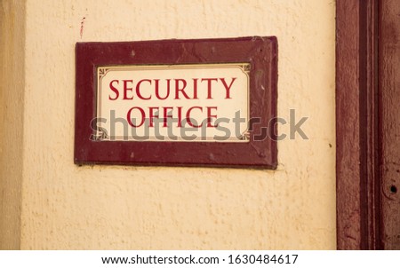Beige retro vintage wall with old sign on brown red frame reading the security office signing old font or style of decoration in the public. Very english way of style show business type lifestyle 
