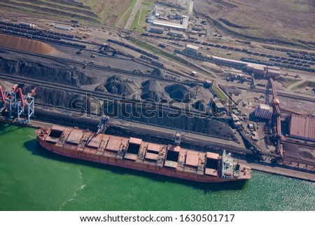 Coal terminal. Open warehouses with coal, ore, stacks. Loading using conveyor equipment, ship-loading machines. Delivery of goods by rail

 Royalty-Free Stock Photo #1630501717
