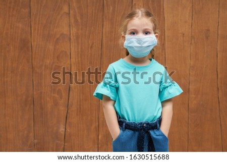 Child in a sterile protective medical mask. Sick little girl. Epidemic of flu. Virus, coronavirus.